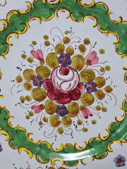 Тарелка винтажная декоративная Im Stil von Italy с округлым цветочным декором, в зеленовато-красных тонах, с фигурным краем, керамика, ручная роспись, 25.5 см, Италия, 1960-70гг.